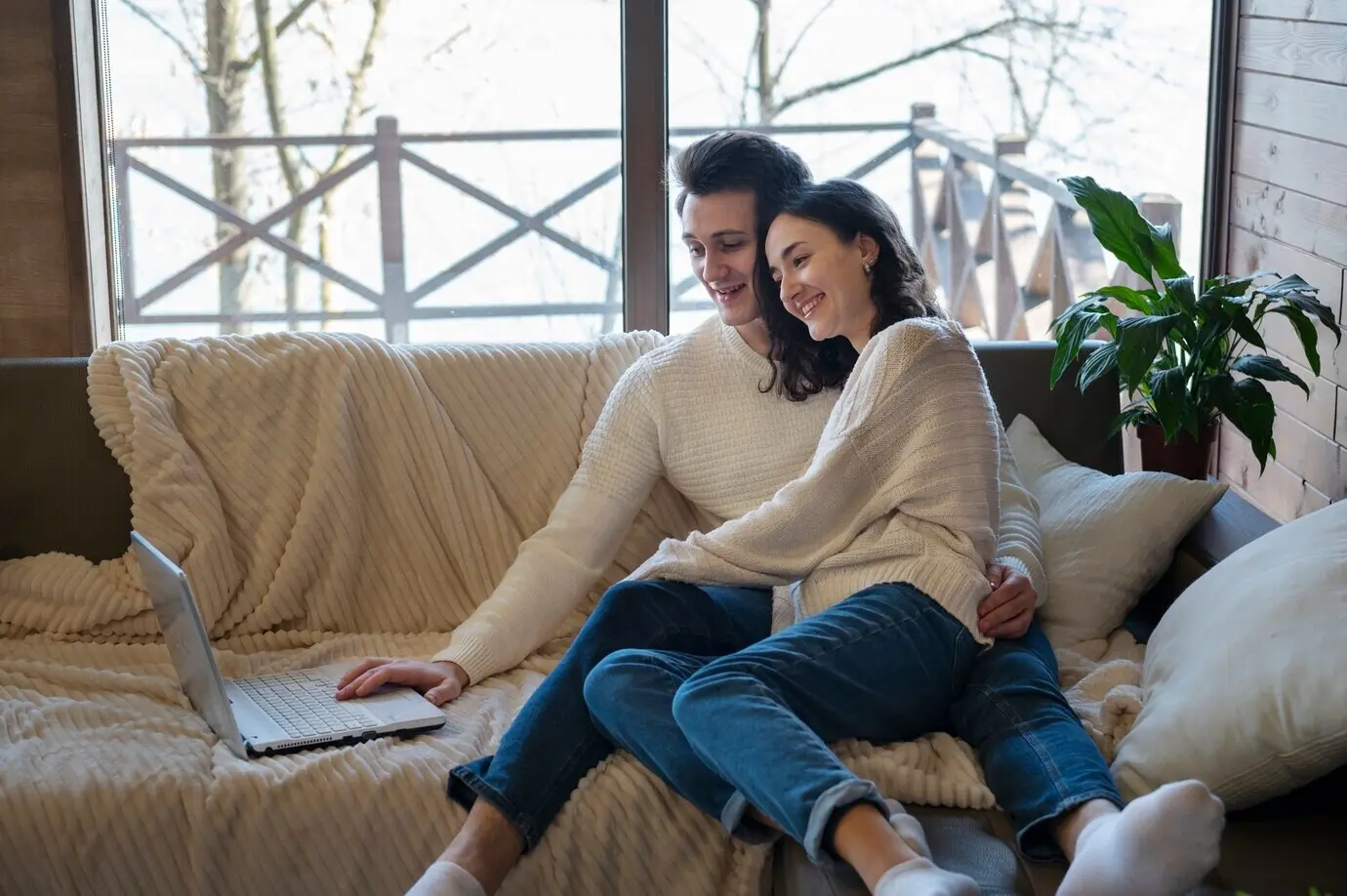 Vollaufnahme von Personen, die zusammen auf einer Couch sitzen.